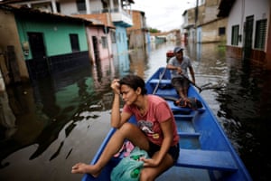 A woman looks on from a canoe after leaving her house during floods caused by heavy rain in Maraba.