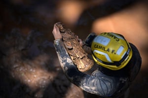 A firefighter finds a statue of a saint in the mud as she carries out inspection works in Raposos after the level of the Rio das Velhas lowered following heavy rains in the state of Minas Gerais.